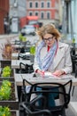 Beautiful young business woman sitting in an outdoor cafe and working with documents. Royalty Free Stock Photo