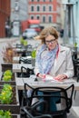 Beautiful young business woman sitting in an outdoor cafe and working with documents. Royalty Free Stock Photo