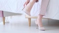 Beautiful young business woman taking her shoes off after a long day. pastel colors, soft focus Royalty Free Stock Photo