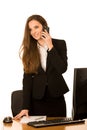 Beautiful young business woman talks on the phone in her office Royalty Free Stock Photo