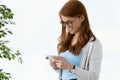 Beautiful young business woman using her mobile phone in the office. Royalty Free Stock Photo