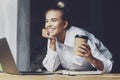 Beautiful young business woman working remotely from home. Smiling woman sits in front of laptop