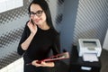 Beautiful young businesswoman in black dress and glasses hold paper folder Royalty Free Stock Photo