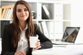 Beautiful young businesswoman holding glass of coffee at workplace Royalty Free Stock Photo