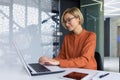 Beautiful young businesswoman inside office working with laptop, blonde with short hair typing on keyboard and smiling Royalty Free Stock Photo