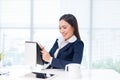 Beautiful young businesswoman sitting at office desk in front of Royalty Free Stock Photo