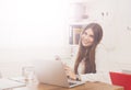 Beautiful young businesswoman sitting by office desk with laptop Royalty Free Stock Photo