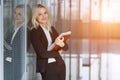 Beautiful young businesswoman smiling and standing with folder in the office. looking at camera. copy space. Royalty Free Stock Photo