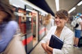 Beautiful young businesswoman waiting in line to enter in subway train, smiling Royalty Free Stock Photo