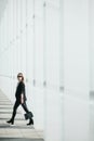 Beautiful young businesswoman walking outside corporate building