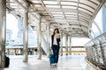 Beautiful young businesswoman walking outside public transportation station. Businesswoman traveler with suitcase on the way to Royalty Free Stock Photo