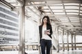 Beautiful young businesswoman walking outside public transportation station. Businesswoman traveler with suitcase on the way to Royalty Free Stock Photo