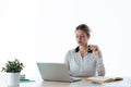 Beautiful young businesswoman working with her laptop in the office over white background. Royalty Free Stock Photo