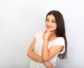 Beautiful young casual cute smiling woman on blue background looking up and thinking. Closeup portrait Royalty Free Stock Photo