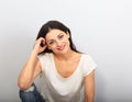 Beautiful young casual cute smiling woman on blue background looking up and thinking sitting in blue jeans. Closeup portrait Royalty Free Stock Photo