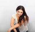 Beautiful young casual cute smiling woman on blue background looking up and thinking sitting in blue jeans. Closeup portrait Royalty Free Stock Photo