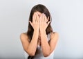 Beautiful young casual woman covering the face the hands on blue background. Closeup. Sad emotion concept Royalty Free Stock Photo