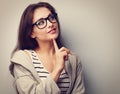 Beautiful young casual woman in glasses thinking with finger under face Royalty Free Stock Photo