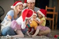 Beautiful young caucasian family gathered for christmas, enjoying together, laughing, sitting on the floor at home. sisters