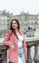 Beautiful young Caucasian female posing in front of a Parisian typical building during the daytime