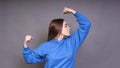 Portrait of cheerful young girl bending biceps isolated on gray background Royalty Free Stock Photo