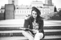 A beautiful, young Caucasian girl sitting on the street smile, the joy, sit with notebook and pen in Ruhi. In the red sweater, jea Royalty Free Stock Photo