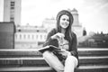 A beautiful, young Caucasian girl sitting on the street smile, the joy, sit with notebook and pen in Ruhi. In the red sweater, jea Royalty Free Stock Photo