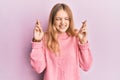 Beautiful young caucasian girl wearing casual clothes gesturing finger crossed smiling with hope and eyes closed Royalty Free Stock Photo