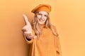 Beautiful young caucasian girl wearing french look with beret smiling friendly offering handshake as greeting and welcoming