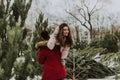 Beautiful young caucasian heterosexual couple of shoppers are choosing and making a purchase at the Christmas tree Royalty Free Stock Photo