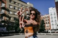 Beautiful young caucasian woman at the city street on a sunny day making V gesture with fingers with happy face smiling. Urban Royalty Free Stock Photo