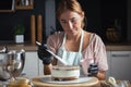 Beautiful young caucasian woman decorating cake with professional tools