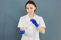 Beautiful young Caucasian woman doctor cosmetologist holding syringe with solution for beauty injections. isolated Royalty Free Stock Photo