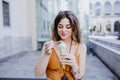 Beautiful young caucasian woman eating mint ice cream at the city street on a sunny day. Happy face smiling. Urban and summer life Royalty Free Stock Photo