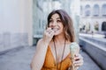 Beautiful young caucasian woman eating mint ice cream at the city street on a sunny day. Happy face smiling. Urban and summer Royalty Free Stock Photo