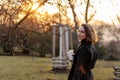 Beautiful young Caucasian woman enjoy sunny spring day, park cherry garden, romantic portrait, drinking coffee, lady in black coat Royalty Free Stock Photo