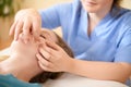 Beautiful young caucasian woman having face massage in spa salon. Relaxed woman having facial massage at the spa. Royalty Free Stock Photo