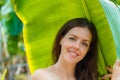 Beautiful young caucasian woman portrait near banana palm leaves tropical plants in jungle. Skin care and natural Royalty Free Stock Photo