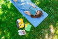 Beautiful young caucasian woman reading a book outdoor. Lying on mat. Top view Royalty Free Stock Photo