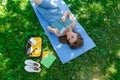 Beautiful young caucasian woman reading a book outdoor. Lying on mat. Top view Royalty Free Stock Photo