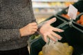 Beautiful young caucasian woman is shopping in transparent gloves in the fruit and vegetable department of a grocery store Royalty Free Stock Photo