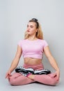 Beautiful young caucasian woman sitting in yoga position and meditating isolated over gray background Royalty Free Stock Photo