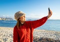 Beautiful young caucasian woman solo traveller make a self portrait herself on the beach at sunset or dawn - Alone female person