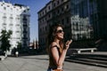Beautiful young caucasian woman walking at the city street on a sunny day. Sending an audio with mobile phone. Happy face smiling Royalty Free Stock Photo