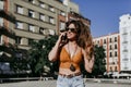 Beautiful young caucasian woman walking at the city street on a sunny day. Talking on mobile phone. Happy face smiling. Urban Royalty Free Stock Photo