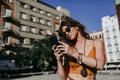 Beautiful young caucasian woman walking at the city street on a sunny day. Talking on mobile phone. Happy face smiling. Urban life Royalty Free Stock Photo