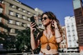 Beautiful young caucasian woman walking at the city street on a sunny day. Talking on mobile phone. Happy face smiling. Urban Royalty Free Stock Photo