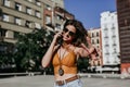 Beautiful young caucasian woman walking at the city street on a sunny day. Talking on mobile phone. Happy face smiling. Urban Royalty Free Stock Photo