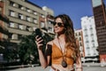 Beautiful young caucasian woman walking at the city street on a sunny day. Talking on mobile phone. Happy face smiling. Urban Royalty Free Stock Photo