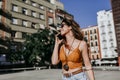 Beautiful young caucasian woman walking at the city street on a sunny day. Talking on mobile phone. Happy face smiling. Urban Royalty Free Stock Photo